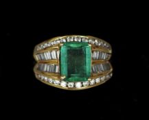 An 18 ct gold diamond and emerald ring
The central emerald flanked by rows of baguette and brilliant