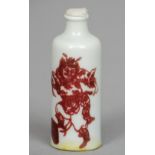 A Chinese porcelain snuff bottle
Iron red painted with a warring figure and stylised bats, blue