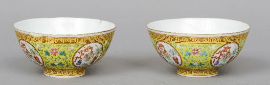 A pair of Chinese yellow ground porcelain bowls
Each decorated with vignettes of precious objects,