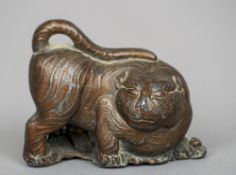 A Chinese bronzed lead tiger 
Modelled crouching before bamboo sprays.  7 cm long. CONDITION