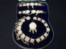 A Victorian unmarked silver filigree suite of jewellery
Comprising: a pair of bracelets, necklace