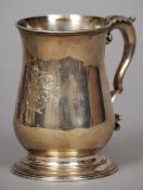 A George III silver mug, hallmarked London 1770, makers mark indistinct
Of waisted form with an