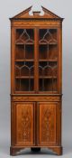 An Edwardian inlaid mahogany standing corner cabinet
The broken dentil moulded cornice above twin