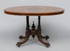 A Victorian burr walnut tilt-top loo table
The figured oval top above turned columns and