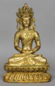 A Chinese gilded bronze turquoise and coral set figure of a deity
Modelled seated cross legged on