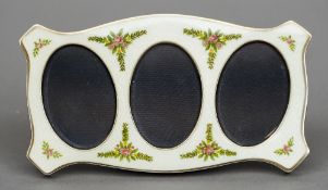 An enamel decorated silver triple photograph frame
Of lobed rectangular form with floral decoration,