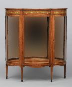 An Edwardian painted satinwood display cabinet
The shaped bowed top above a floral bow tied swag