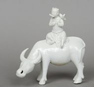 An 18th century Chinese blanc de chine porcelain figural group
Formed as a boy seated on a