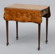 A George III mahogany Pembroke table
The crossbanded shaped twin flap top above a frieze drawer with