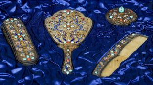 A cased Chinese enamel decorated silver dressing table set
Comprising: hand mirror, a brush, comb,