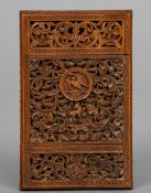 An Eastern carved wood card case
Profusely worked and pierced with exotic birds amongst foliate