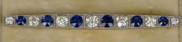 An Art Deco diamond and sapphire set unmarked white metal bar brooch
The central stone approximately