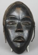 An African carved tribal mask
With applied plaited hair.  23.5 cm high. CONDITION REPORTS: Generally