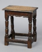 A 17th century and later oak joint stool
With turned and block legs and shaped apron.  45.5 cm wide.