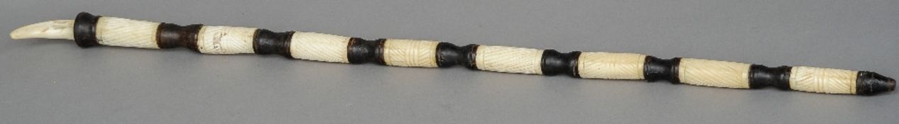 An African carved bone and ebonised staff
Surmounted with a boar's tooth.  98 cm long. CONDITION