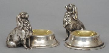 A pair of silver plated salts
Each modelled as a dog sat expectantly beside a gilded bowl.