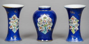 A Chinese porcelain trio
Decorated with floral vignettes on a blue ground.  The vases 10.5 cm high.