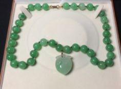 A carved jade bead necklace with peach carved pendant
The necklace approximately 56.5 cm long.