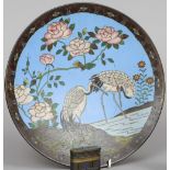 A Chinese cloisonne plate
Typically decorated with cranes in a river landscape with floral