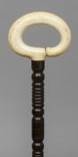 A 19th century ivory handled rosewood walking stick 
The ivory loop handle above the turned shaft