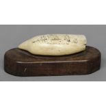 A 19th century scrimshaw sperm whale tooth 
Probably later carved with Whalers in the Ice, mounted