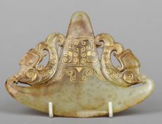 A carved russet jade pendant
Of axe form, carved with mermen and gilt decorated.  14 cm wide.