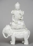 A Chinese blanc de chine figure of Guanyin
Modelled seated on an elephant holding a lotus