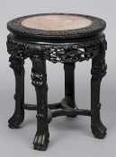 A late 19th/early 20th century Chinese marble topped carved hardwood urn stand
Of typical circular