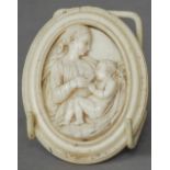 A 19th century Dieppe carved ivory plaque
Formed as a mother breast feeding her child.  8 cm high.