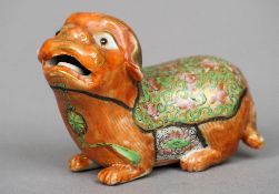 A Chinese porcelain temple dog
Modelled gazing upward with open mouth, signed.  8.5 cm long.