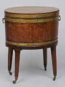 A Georgian brass bound mahogany wine cooler
Of oval form with brass bands and brass loop handles,