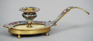 A Continental champleve decorated chamberstick
With flattened handle and flowerhead drip-pan,