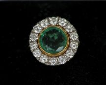 An 18 ct gold diamond and emerald ring
The circular facet cut emerald surrounded by a band of