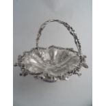 A SILVERPLATED CIRCULAR SWING HANDLE FRUIT BASKET. Engraved with pomegranates, leaves and C-