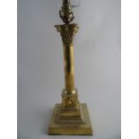 A BRASS CORINTHIAN COLUMN TABLE LAMP AND SHADE. 40cm high