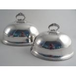A PAIR OF LARGE AND SMALL SILVERPLATED OVAL MEAT DOMES. Bead and leaf scroll handles and oval bead