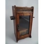 AN EDWARDIAN OAK SMOKER'S CABINET. Glazed door with small drawer and drop down pipe racks. 32.5 x 16