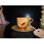 A Royal Worcester hand painted cabinet cup and saucer with pheasant decoration