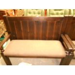 A 20th C two seat stained pine panel bac