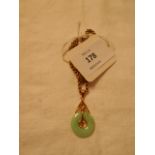 A 14k gold and jade disc pendant and chain