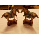 A pair of painted ivory Tang horses resting on carved wood stands with wire inlay