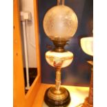 A Victorian oil lamp with acid etched glass shade and yellow glass reservoir hand-painted with