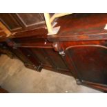 A large Victorian mahogany inverted break-front sideboard having floral carved mirror back above a
