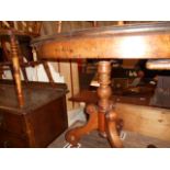 A small late Victorian oval mahogany centre table raised on turned column supports and three