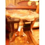 A mid 20th C mahogany wine table the shaped top carved with lily pad and blossoms,