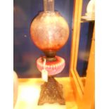 A Victorian oil lamp with floral etched shade and lobbed pink milk glass reservoir,