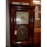 A walnut cased American wall clock with enamelled floral painted dial and Roman numerals above a