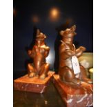 A pair of copper coloured bear bookends resting on marble bases