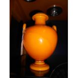 A Uranium orange glazed two handled urn shaped vase possibly Pilkington mark to base England,