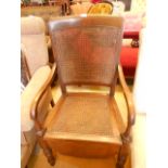 A mid-20th C walnut cane backed commode chair